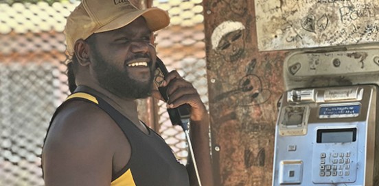 A man using a payphone in the outback